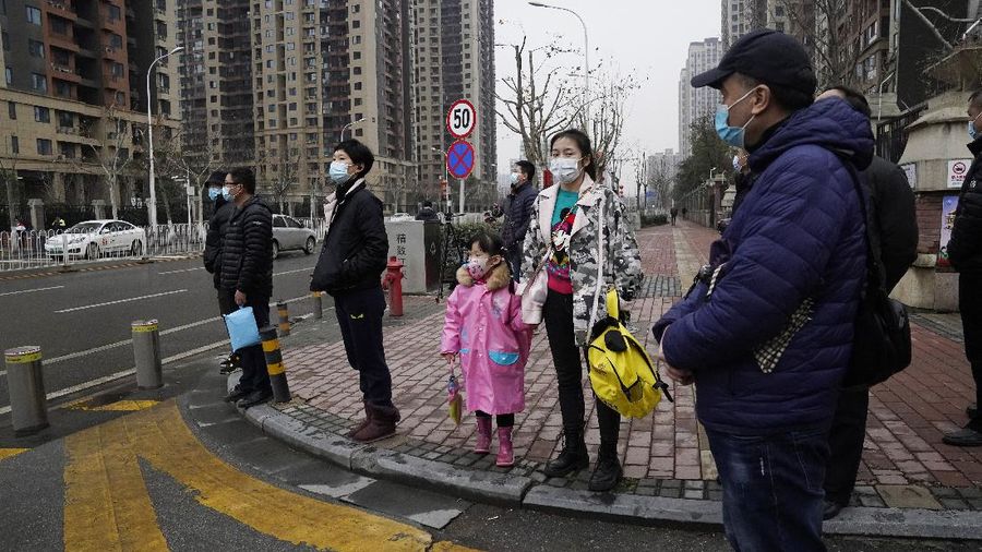 The World Health Organization team is briefed outside of the Huanan Seafood Market on the third day of their field visit in Wuhan, China, Sunday, Jan. 31, 2021. Scientists initially suspected the coronavirus came from wild animals sold in the market. The market has since been largely ruled out but for the visiting WHO team of international researchers it could still provide hints to how the virus spread so widely. (AP Photo/Ng Han Guan)