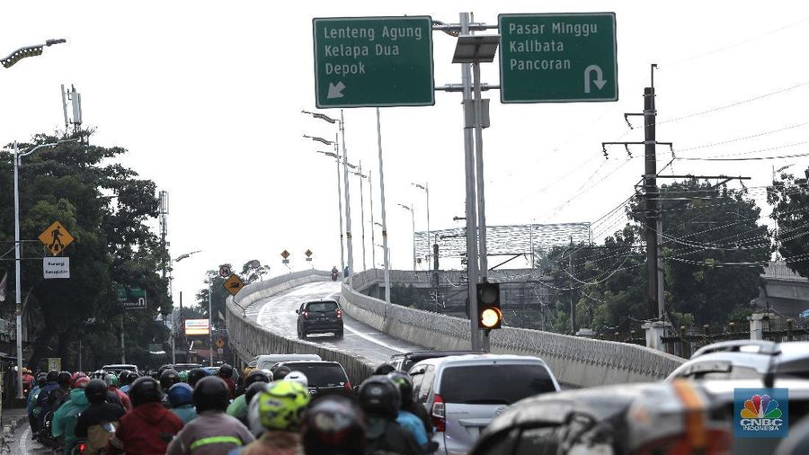 Warga melintasi Flyover Lenteng Agung di Jakarta Selatan, Senin (1/2/2021). Dinas Bina Marga DKI Jakarta melakukan uji coba lalu lintas di jalan layang tapal kuda Lenteng Agung dan Tanjung Barat selama 3 hari. Dimulai hari Minggu (31/1) pukul 08.00 WIB hingga pukul 21.00 WIB serta hari Senin (1/2) dan Selasa (2/2) pukul 06.00 WIB hingga 21.00 WIB. Uji coba dilakukan untuk mengevaluasi kekurangan pekerjaan yang ada di lapangan seperti marka, rambu dan kelengkapan jalan. Sejumlah tanda penunjuk jalan hingga fasilitas perjalanan juga telah dipasang di flyover ini. Gubernur DKI Jakarta Anies Baswedan meyakini jalan layang atau flyover Tapal Kuda bisa menyelesaikan masalah kemacetan di kawasan Pasar Minggu-Lenteng Agung, Jakarta Selatan.  (CNBC Indonesia/ Muhammad Sabki)
