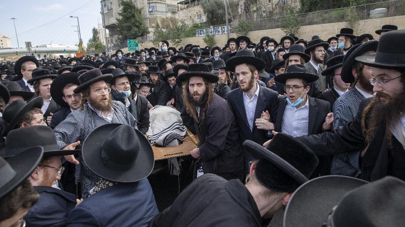 Thousands of ultra-Orthodox Jews participate in tfuneral for prominent rabbi Meshulam Soloveitchik, in Jerusalem, Sunday, Jan. 31, 2021. The mass ceremony took place despite the country's health regulations banning large public gatherings, during a nationwide lockdown to curb the spread of the virus. (AP Photo/Ariel Schalit)