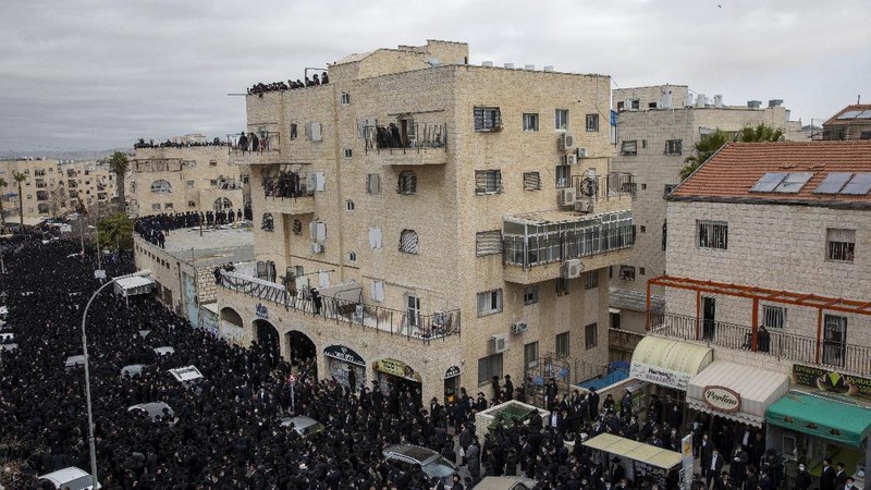 Thousands of ultra-Orthodox Jews participate in tfuneral for prominent rabbi Meshulam Soloveitchik, in Jerusalem, Sunday, Jan. 31, 2021. The mass ceremony took place despite the country's health regulations banning large public gatherings, during a nationwide lockdown to curb the spread of the virus. (AP Photo/Ariel Schalit)