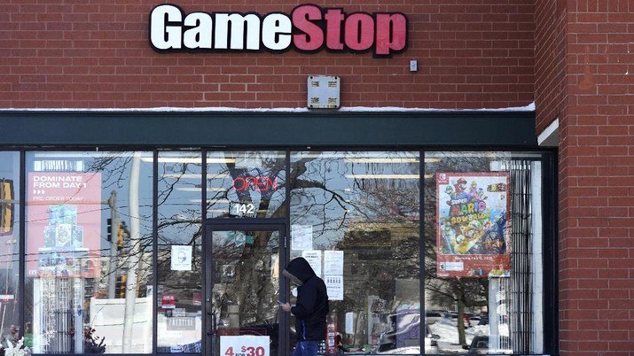 A customer checks on his cellphone as he walks to a GameStop store in Vernon Hills, Ill., Thursday, Jan. 28, 2021. The online trading platform Robinhood is moving to restrict trading in GameStop and other stocks that have soared recently due to rabid buying by smaller investors. GameStop stock has rocketed from below $20 to around $350 this month as a volunteer army of investors on social media challenged big institutions who has placed market bets that the stock would fall. (AP Photo/Nam Y. Huh)
