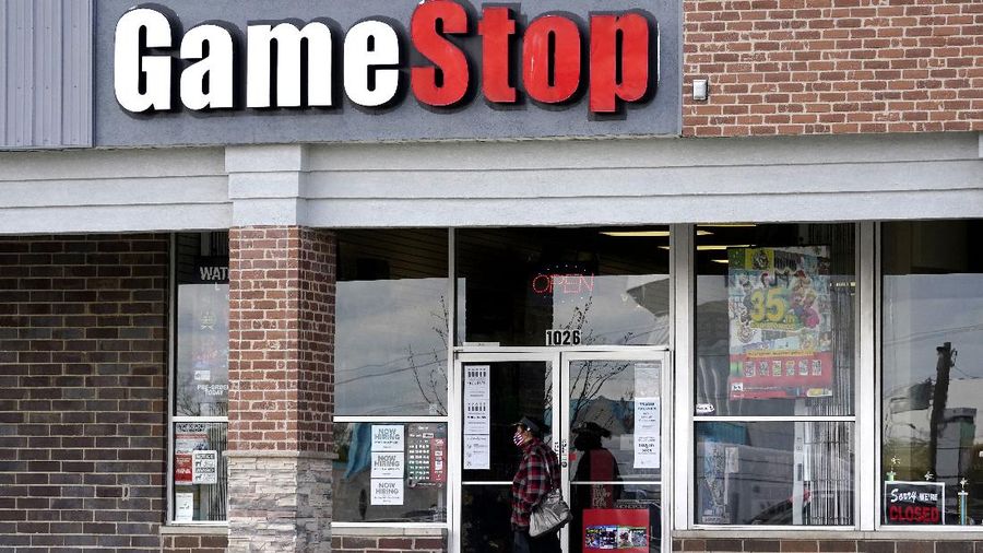 A woman wears a face mask as she walks past a GameStop store in Des Plaines, Ill., Thursday, Oct. 15, 2020. The latest battleground between the proletariat and the hedge funds serving the 1% isn’t on just any street. It’s on Wall Street. At least, that’s the view within an army of smaller-pocketed, optimistic investors who are throwing dollars and buy orders at the stock of video-game retailer GameStop. (AP Photo/Nam Y. Huh, file)