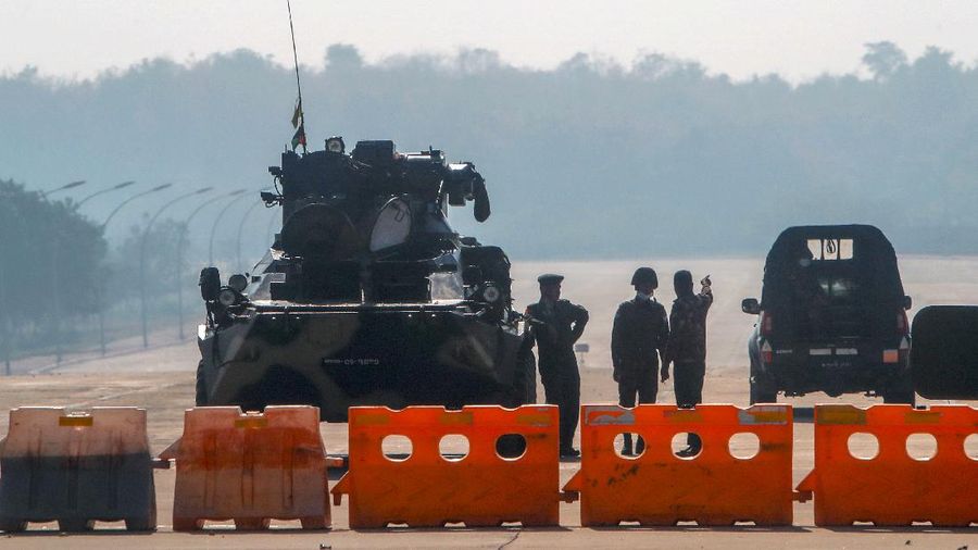 Myanmar's military stand guard at a checkpoint manned with an armored vehicle in a road leading to the parliament building Tuesday, Feb. 2, 2021, in Naypyitaw, Myanmar. Hundreds of members of Myanmar's Parliament remained confined inside their government housing in the country's capital on Tuesday, a day after the military staged a coup and detained senior politicians including Nobel laureate and de facto leader Aung San Suu Kyi. (AP Photo)