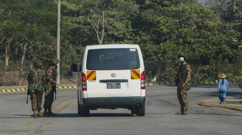 Myanmar's military stand guard at a checkpoint manned with an armored vehicles blocking a road leading to the parliament building Tuesday, Feb. 2, 2021, in Naypyitaw, Myanmar. Hundreds of members of Myanmar's Parliament remained confined inside their government housing in the country's capital on Tuesday, a day after the military staged a coup and detained senior politicians including Nobel laureate and de facto leader Aung San Suu Kyi. (AP Photo)