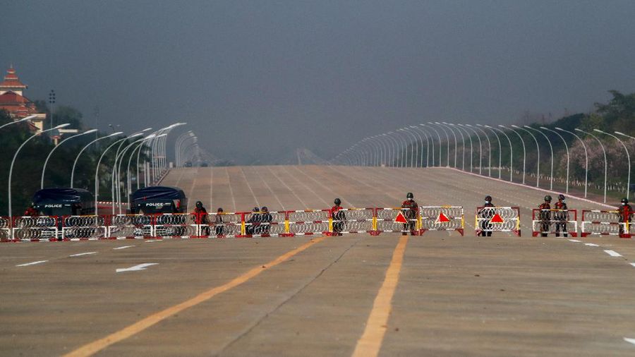 Myanmar's soldiers stand guard at a barricaded road leading to the parliament building Tuesday, Feb. 2, 2021, in Naypyitaw, Myanmar. Hundreds of members of Myanmar's Parliament remained confined inside their government housing in the country's capital on Tuesday, a day after the military staged a coup and detained senior politicians including Nobel laureate and de facto leader Aung San Suu Kyi. (AP Photo)