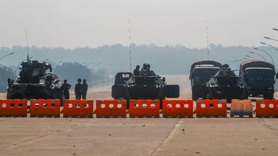 Myanmar's military stand guard at a checkpoint manned with an armored vehicles blocking a road leading to the parliament building Tuesday, Feb. 2, 2021, in Naypyitaw, Myanmar. Hundreds of members of Myanmar's Parliament remained confined inside their government housing in the country's capital on Tuesday, a day after the military staged a coup and detained senior politicians including Nobel laureate and de facto leader Aung San Suu Kyi. (AP Photo)