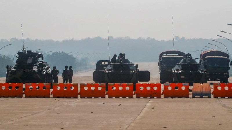 Myanmar's military stand guard at a checkpoint manned with an armored vehicles blocking a road leading to the parliament building Tuesday, Feb. 2, 2021, in Naypyitaw, Myanmar. Hundreds of members of Myanmar's Parliament remained confined inside their government housing in the country's capital on Tuesday, a day after the military staged a coup and detained senior politicians including Nobel laureate and de facto leader Aung San Suu Kyi. (AP Photo)