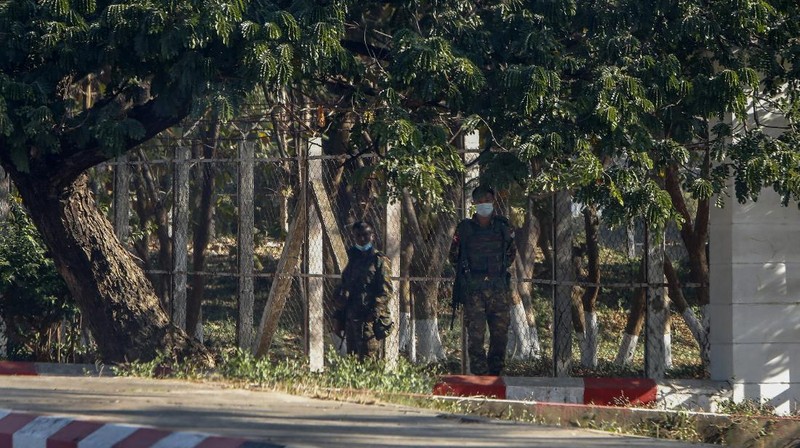 Myanmar's military stand guard at a checkpoint manned with an armored vehicles blocking a road leading to the parliament building Tuesday, Feb. 2, 2021, in Naypyitaw, Myanmar. Hundreds of members of Myanmar's Parliament remained confined inside their government housing in the country's capital on Tuesday, a day after the military staged a coup and detained senior politicians including Nobel laureate and de facto leader Aung San Suu Kyi. (AP Photo)