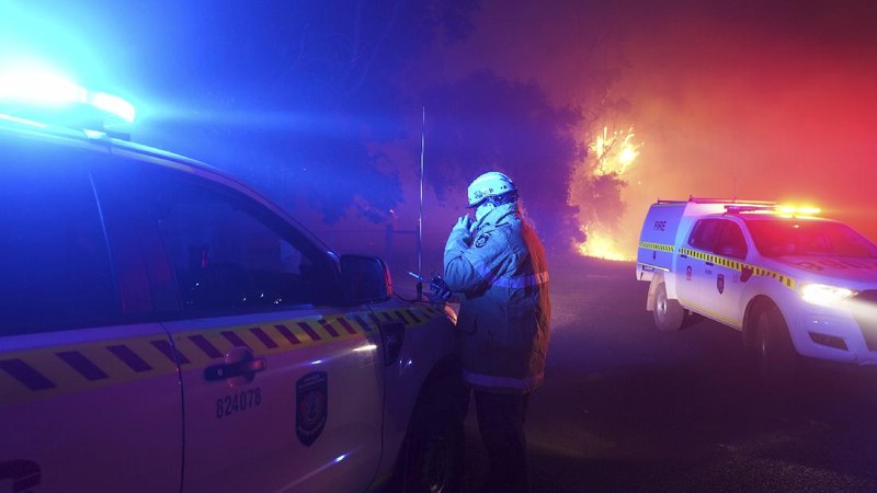 Firefighters attend a fire at Wooroloo, near Perth, Australia, Monday, Feb. 1, 2021. An out-of-control wildfire burning northeast of the Australian west coast city of Perth has destroyed an estimated 30 homes and was threatening more Tuesday, with many locals across the region told it is too late to leave. (Evan Collis/DFES via AP)
