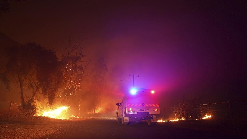 Firefighters attend a fire at Wooroloo, near Perth, Australia, Monday, Feb. 1, 2021. An out-of-control wildfire burning northeast of the Australian west coast city of Perth has destroyed an estimated 30 homes and was threatening more Tuesday, with many locals across the region told it is too late to leave. (Evan Collis/DFES via AP)