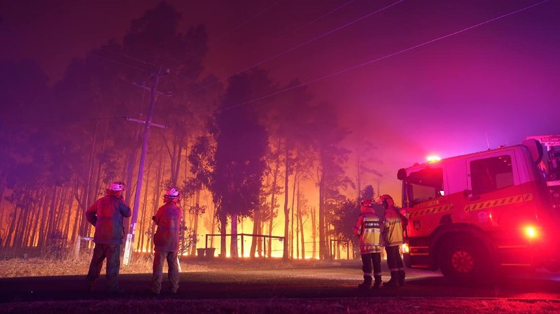 Firefighters attend a fire at Wooroloo, near Perth, Australia, Monday, Feb. 1, 2021. An out-of-control wildfire burning northeast of the Australian west coast city of Perth has destroyed an estimated 30 homes and was threatening more Tuesday, with many locals across the region told it is too late to leave. (Evan Collis/DFES via AP)
