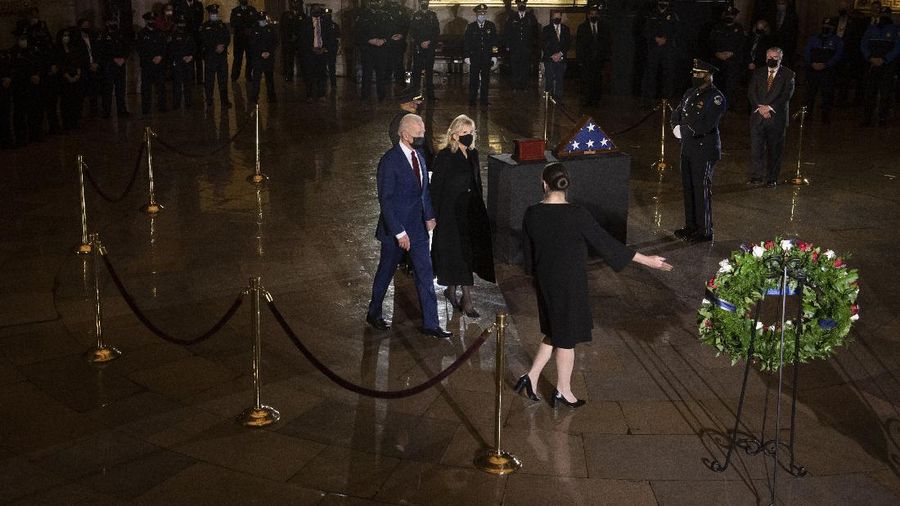 President Joe Biden and first lady Jill Biden leave after paying their respects to U.S. Capitol Police officer Brian Sicknick as an urn with his cremated remains lies in honor on a black-draped table in the Capitol Rotunda, Tuesday, Feb. 2, 2021, in Washington. (Brendan Smialowski/Pool via AP)