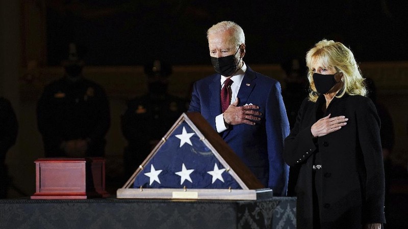 President Joe Biden and first lady Jill Biden leave after paying their respects to U.S. Capitol Police officer Brian Sicknick as an urn with his cremated remains lies in honor on a black-draped table in the Capitol Rotunda, Tuesday, Feb. 2, 2021, in Washington. (Brendan Smialowski/Pool via AP)