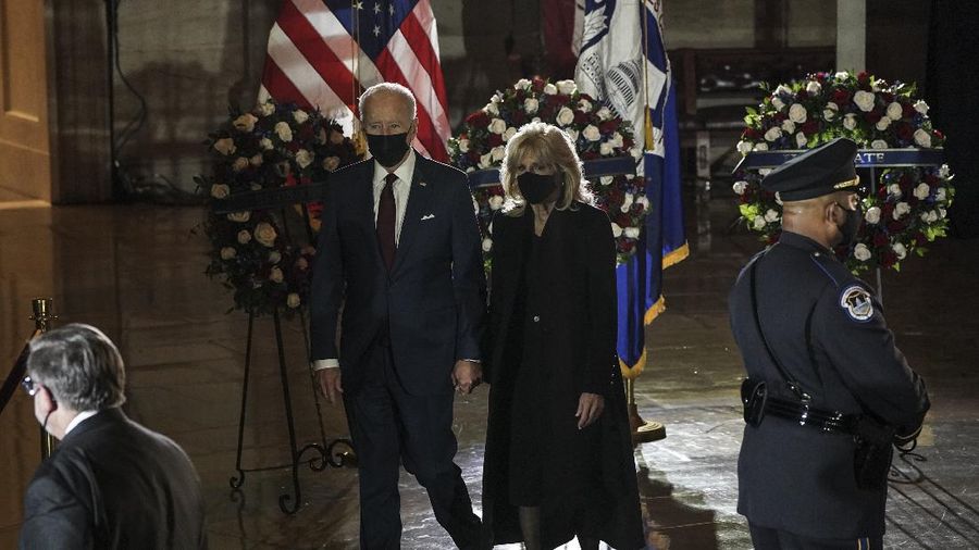President Joe Biden and first lady Jill Biden leave after paying their respects to U.S. Capitol Police officer Brian Sicknick as an urn with his cremated remains lies in honor on a black-draped table in the Capitol Rotunda, Tuesday, Feb. 2, 2021, in Washington. (Brendan Smialowski/Pool via AP)