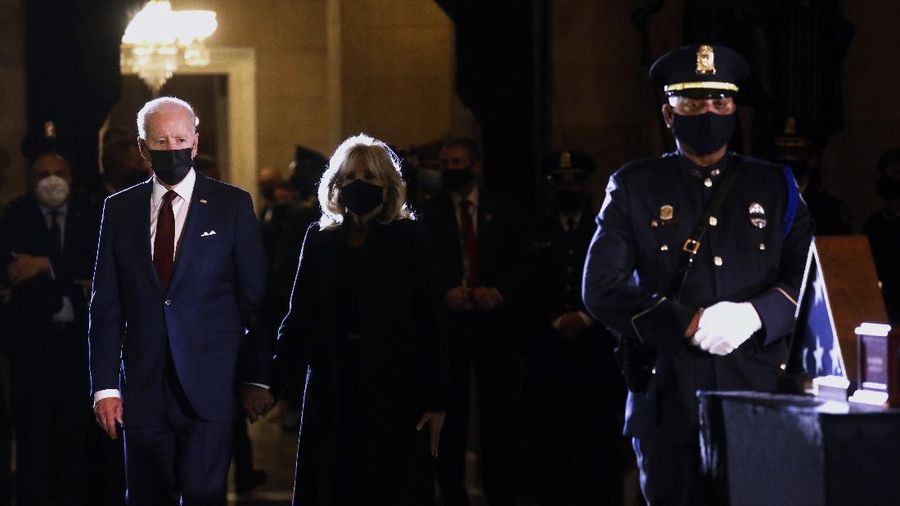President Joe Biden and first lady Jill Biden leave after paying their respects to U.S. Capitol Police officer Brian Sicknick as an urn with his cremated remains lies in honor on a black-draped table in the Capitol Rotunda, Tuesday, Feb. 2, 2021, in Washington. (Brendan Smialowski/Pool via AP)