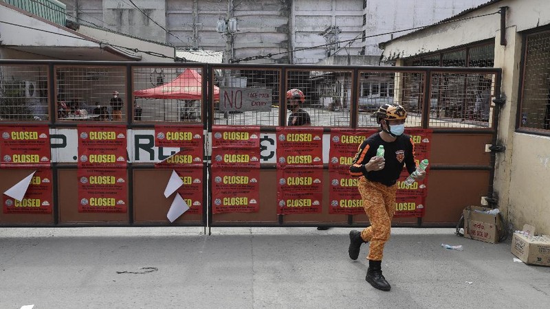 Rescuers stand inside the compound of the TP Marcelo Ice Plant Thursday, Feb. 4, 2021 in Navotas, Philippines. An ammonia leak from the ice plant in the Philippine capital region left some dead and more than 90 other injured or sickened while hundreds of residents fled to safety, an official said. The plant was ordered closed shortly after the leak. (AP Photo/Aaron Favila)