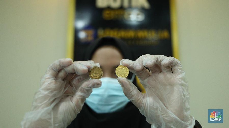 Petugas menunjukkan koin emas Dirham di Gerai Butik Emas Antam, Jakarta, Kamis (4/2/2021). Bank Indonesia (BI) mengajak masyarakat dan berbagai pihak untuk menjaga kedaulatan Rupiah sebagai mata uang NKRI.    (CNBC Indonesia/ Tri Susislo)
