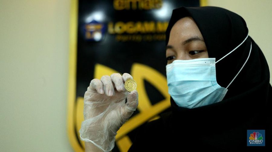 Petugas menunjukkan koin emas Dirham di Gerai Butik Emas Antam, Jakarta, Kamis (4/2/2021). Bank Indonesia (BI) mengajak masyarakat dan berbagai pihak untuk menjaga kedaulatan Rupiah sebagai mata uang NKRI.    (CNBC Indonesia/ Tri Susislo)