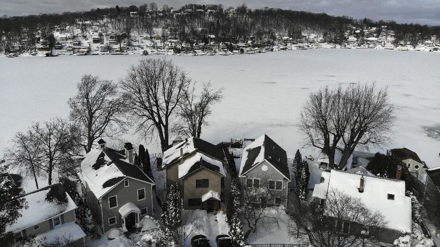 Houses along the shore of a snowed-over Lake Hopatcong are seen in Mt. Arlington, N.J., Wednesday, Feb. 3, 2021. This week's winter storm appears to have broken a 122-year-old record for the most snow in a New Jersey community from one storm. The National Weather Service made a preliminary report Tuesday that Mount Arlington in the northern part of the state got 35.5 inches of snow in the three-day storm. (AP Photo/Seth Wenig)