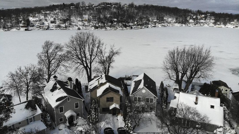 Houses along the shore of a snowed-over Lake Hopatcong are seen in Mt. Arlington, N.J., Wednesday, Feb. 3, 2021. This week's winter storm appears to have broken a 122-year-old record for the most snow in a New Jersey community from one storm. The National Weather Service made a preliminary report Tuesday that Mount Arlington in the northern part of the state got 35.5 inches of snow in the three-day storm. (AP Photo/Seth Wenig)