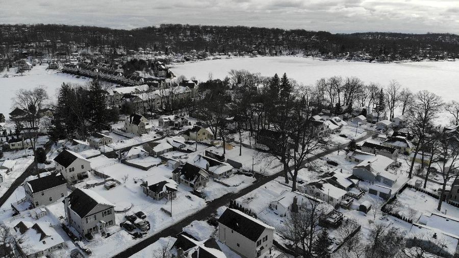 Houses along the shore of a snowed-over Lake Hopatcong are seen in Mt. Arlington, N.J., Wednesday, Feb. 3, 2021. This week's winter storm appears to have broken a 122-year-old record for the most snow in a New Jersey community from one storm. The National Weather Service made a preliminary report Tuesday that Mount Arlington in the northern part of the state got 35.5 inches of snow in the three-day storm. (AP Photo/Seth Wenig)