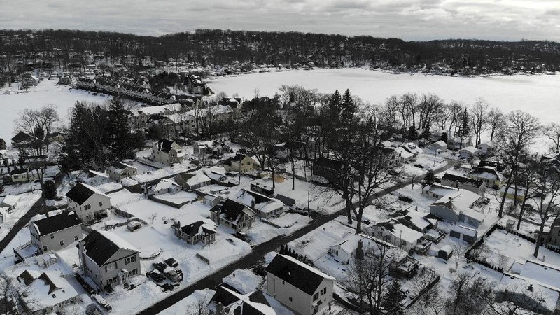 Houses along the shore of a snowed-over Lake Hopatcong are seen in Mt. Arlington, N.J., Wednesday, Feb. 3, 2021. This week's winter storm appears to have broken a 122-year-old record for the most snow in a New Jersey community from one storm. The National Weather Service made a preliminary report Tuesday that Mount Arlington in the northern part of the state got 35.5 inches of snow in the three-day storm. (AP Photo/Seth Wenig)