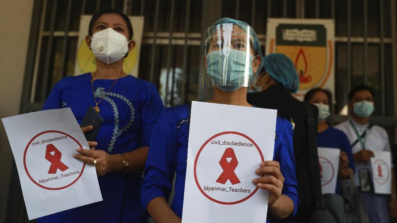 Staffers of the University Hospital hold signs that read 