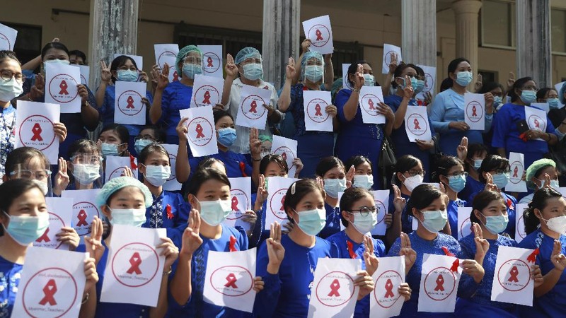 Staffers of the University Hospital hold signs that read 
