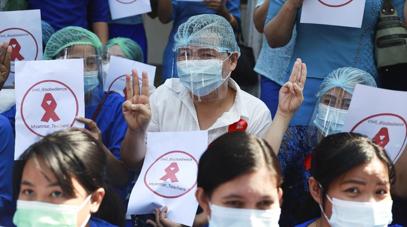 Staffers of the University Hospital hold signs that read 