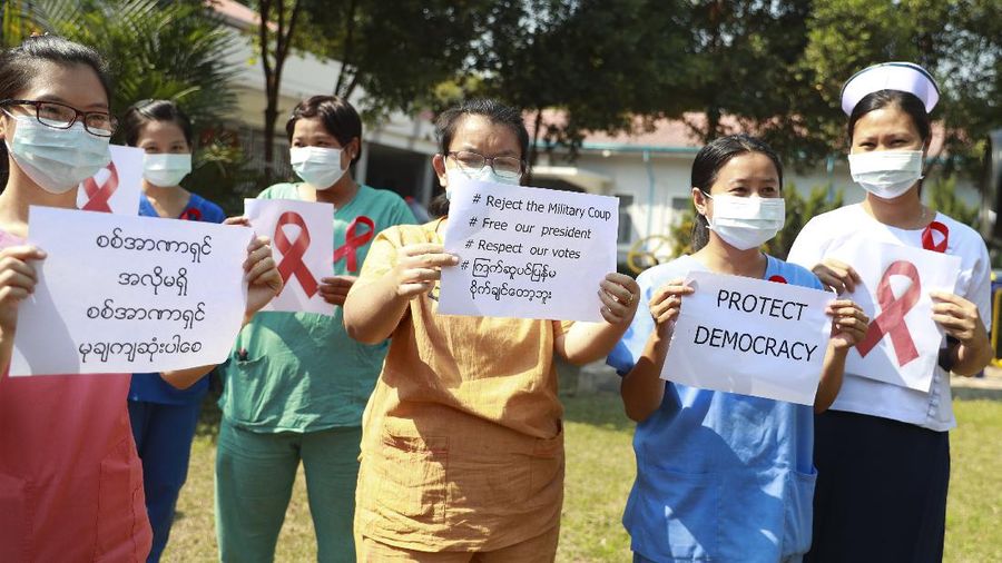 Staffers of the University Hospital hold signs that read 