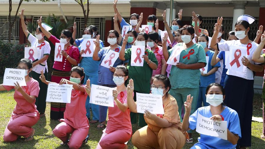 Staffers of the University Hospital hold signs that read 