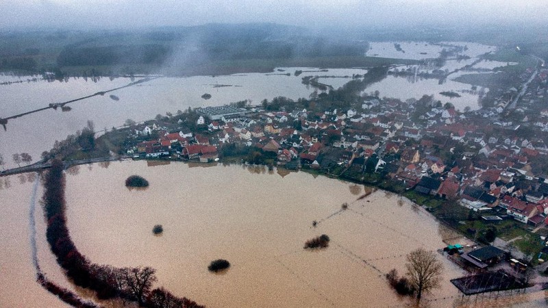 A railroad crossing is surrounded by floodwaters from rain and melting snow in Nidderau near Frankfurt, Germany, Wednesday, Feb. 3, 2021. (AP Photo/Michael Probst)