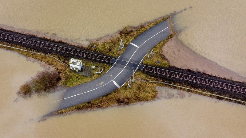 A railroad crossing is surrounded by floodwaters from rain and melting snow in Nidderau near Frankfurt, Germany, Wednesday, Feb. 3, 2021. (AP Photo/Michael Probst)