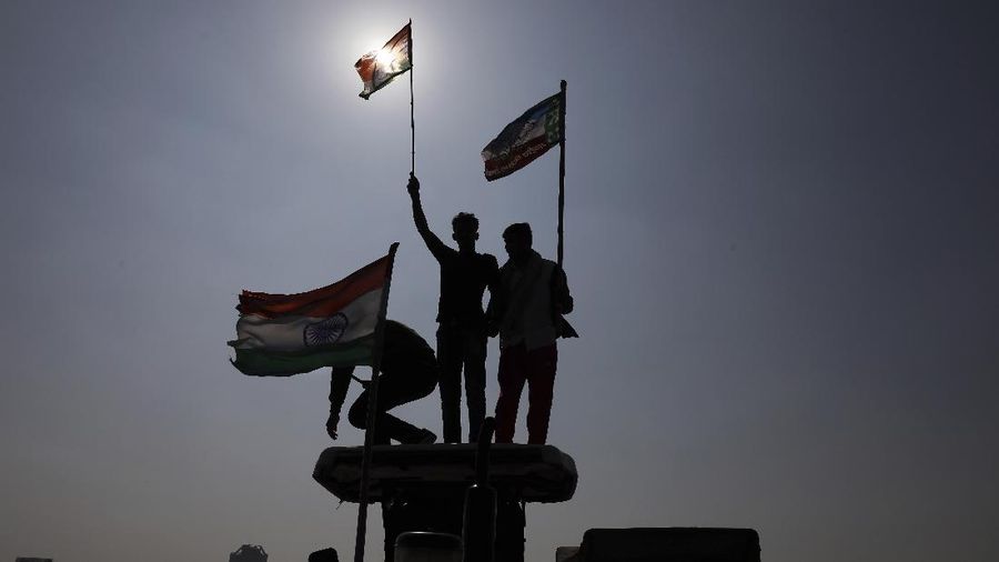 A woman participates in a protest against new farm laws in Mumbai, India, Saturday, Feb. 6, 2021. Tens of thousands of protesting Indian farmers blocked highways across the country for three hours Saturday to press their demands for the repeal of new agricultural laws. (AP Photo/Rafiq Maqbool)