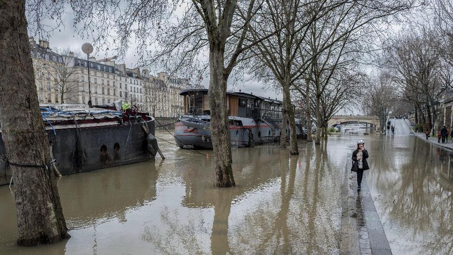A rescue worker, left, and volunteers help residents in a flooded street of Le Gond-Pontouvre, near Angouleme, southwestern France, Friday, Feb 5, 2021. In southern France, waters are starting to recede after the worst flooding in 40 years swelled the Garonne River between Bordeaux and Toulouse. (AP Photo/Yohan Bonnet)