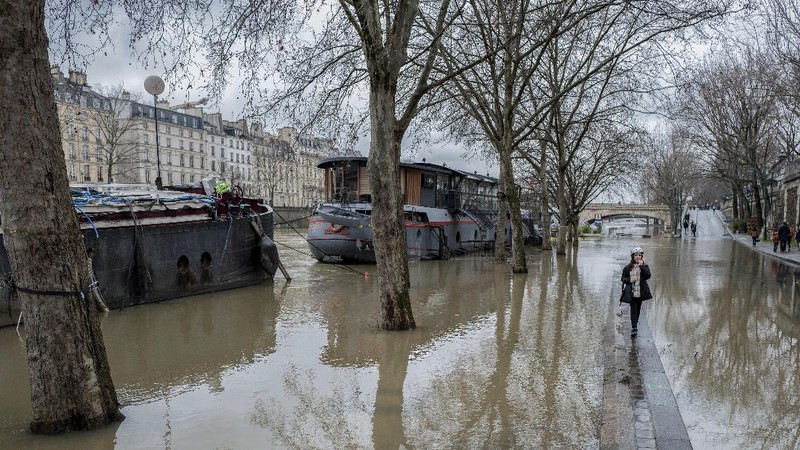 A rescue worker, left, and volunteers help residents in a flooded street of Le Gond-Pontouvre, near Angouleme, southwestern France, Friday, Feb 5, 2021. In southern France, waters are starting to recede after the worst flooding in 40 years swelled the Garonne River between Bordeaux and Toulouse. (AP Photo/Yohan Bonnet)