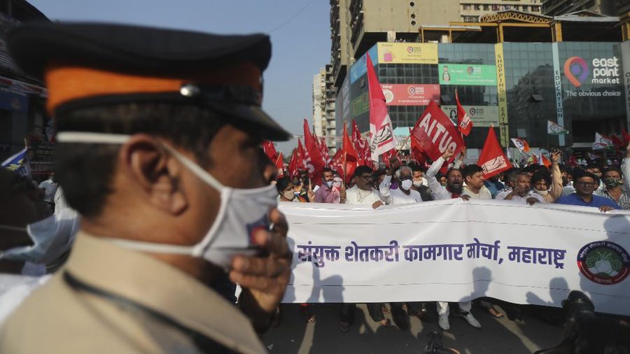 A woman participates in a protest against new farm laws in Mumbai, India, Saturday, Feb. 6, 2021. Tens of thousands of protesting Indian farmers blocked highways across the country for three hours Saturday to press their demands for the repeal of new agricultural laws. (AP Photo/Rafiq Maqbool)