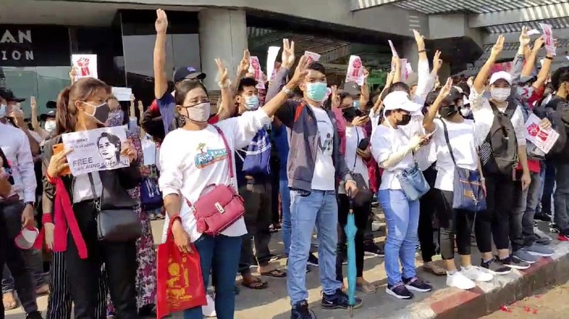 In this image made from video provided by the Democratic Voice of Burma (DVB), protesters hold an image of deposed Myanmar leader Aung San Suu Kyi and former President Win Myint outside the Hladen Center in Yangon, Myanmar Sunday, Feb. 7, 2021.  About 2,000 protesters rallied against the military takeover in Myanmar's biggest city on Sunday and demanded the release of Aung San Suu Kyi, whose elected government was toppled by the army that also imposed an internet blackout.  (DVB via AP)