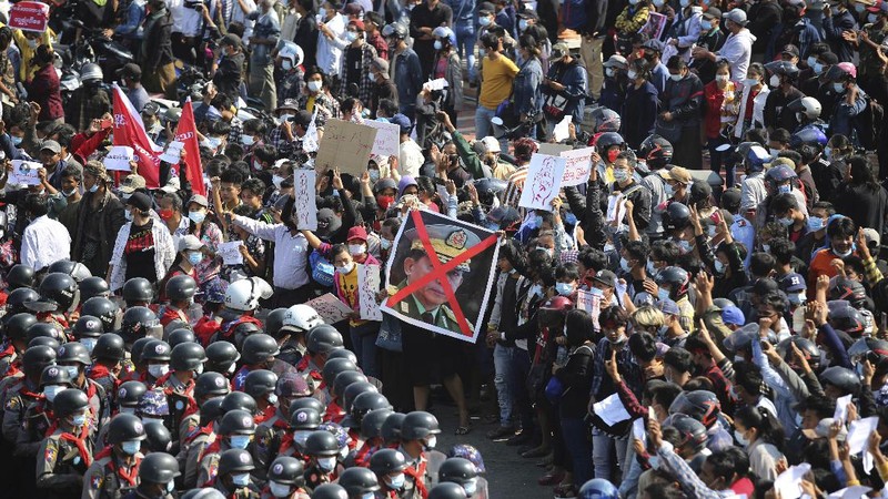 Protesters are sprayed with water fired from a police truck's water cannon in Naypyitaw, Myanmar on Monday, Feb. 8, 2021. Tension in the confrontations between the authorities and demonstrators against last week's coup in Myanmar boiled over Monday, as police fired a water cannon at peaceful protesters in the capital Naypyitaw.(AP Photo)
