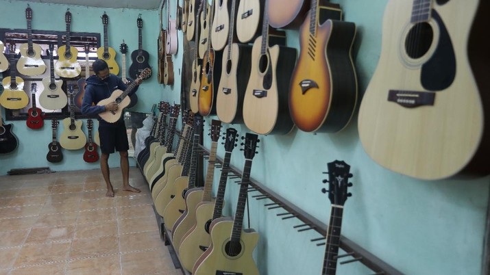 Jasa Service Gitar (CNBC Indonesia/Andrean Kristianto) Pengrajjn memperbaiki gitar pelanggan di servis gitar pak Manto, Jakarta Selatan, Senin (8/2/2021). Selain mereparasi gitar, Manto juga memproduksi gitar akustik yang dijual dari harga ratusan ribu hingga juta, tergantung jenis dan tingkat kesulitannya. (CNBC Indonesia/Andrean Kristianto)
