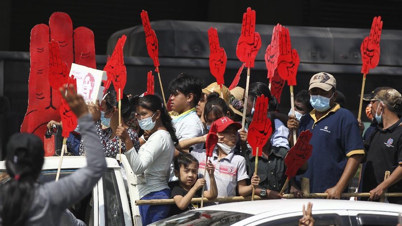 Protesters are sprayed with water fired from a police truck's water cannon in Naypyitaw, Myanmar on Monday, Feb. 8, 2021. Tension in the confrontations between the authorities and demonstrators against last week's coup in Myanmar boiled over Monday, as police fired a water cannon at peaceful protesters in the capital Naypyitaw.(AP Photo)