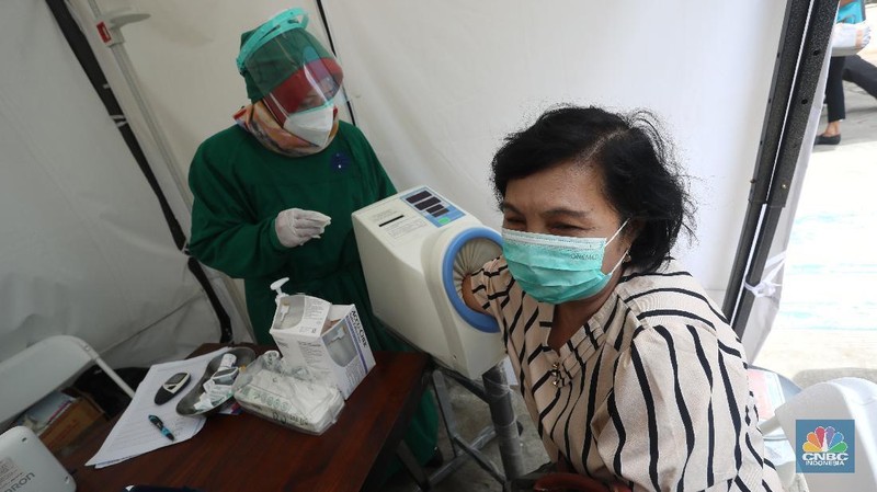 Petugas menyuntikkan vaksin COVID-19 produksi Sinovac kepada tenaga kesehatan berusia lanjut saat kegiatan vaksinasi massal dosis pertama di Puskesmas Kecamatan Kramat Jati, Jakarta, Senin (8/2/2021). Kementerian Kesehatan (Kemenkes) memulai vaksinasi tenaga kesehatan di atas 60 tahun setelah Badan Pengawas Obat dan Makanan (BPOM) mengeluarkan izin penggunaan vaksin tersebut untuk lansia. (CNBC Indonesia/Andrean Kristianto)