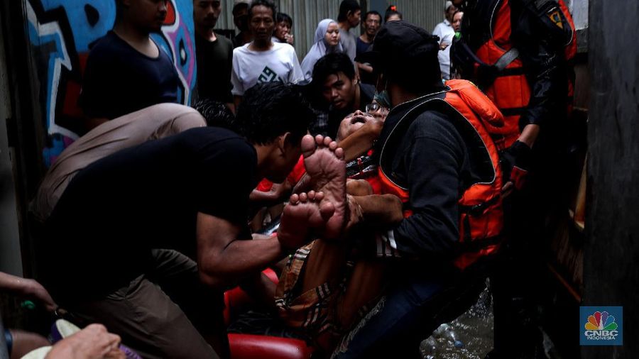 Tim SAR mengevakuasi warga yang terjebak banjir di kampung Kebon Pala, Jakarta, Senin (8/2/2021). (CNBC Indonesia/Tri Susilo)