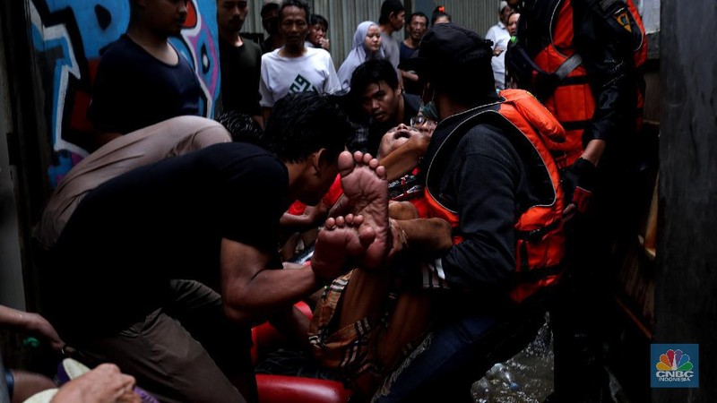 Tim SAR mengevakuasi warga yang terjebak banjir di kampung Kebon Pala, Jakarta, Senin (8/2/2021). (CNBC Indonesia/Tri Susilo)