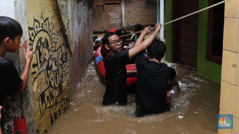 Tim SAR mengevakuasi warga yang terjebak banjir di kampung Kebon Pala, Jakarta, Senin (8/2/2021). (CNBC Indonesia/Tri Susilo)