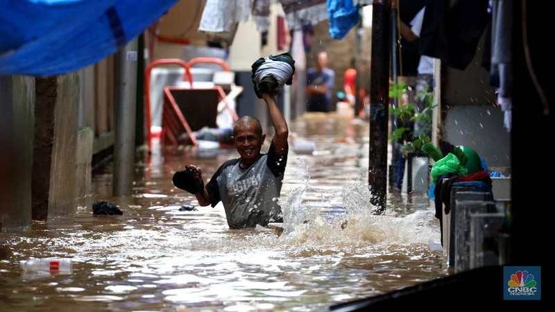 Tim SAR mengevakuasi warga yang terjebak banjir di kampung Kebon Pala, Jakarta, Senin (8/2/2021). (CNBC Indonesia/Tri Susilo)