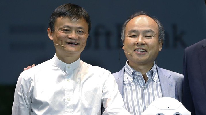 FILE - In this June 18, 2015, file photo, Softbank Corp. CEO Masayoshi Son, right, Alibaba Group Executive Chairman Jack Ma, left, of China with Foxconn Chairman and CEO Terry Gou of Taiwan pose for photographers with Softbank's Pepper robot during a press conference in Maihama, near Tokyo. Son, the chief executive of Japanese technology company SoftBank Group Corp. said Thursday, June 25, 2020, that he is stepping down from the board of Chinese e-commerce giant Alibaba. (AP Photo/Shizuo Kambayashi)