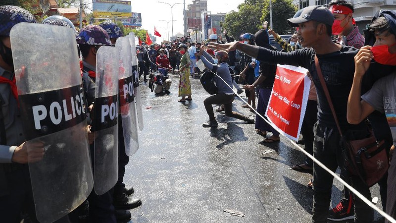 Protesters regroup after police fired warning-shots and used a water cannon to disperse them during a protest in Mandalay, Myanmar on Tuesday, Feb. 9, 2021. Police cracked down Tuesday on the demonstrators protesting against Myanmar’s military takeover who took to the streets in defiance of new protest bans. (AP Photo)