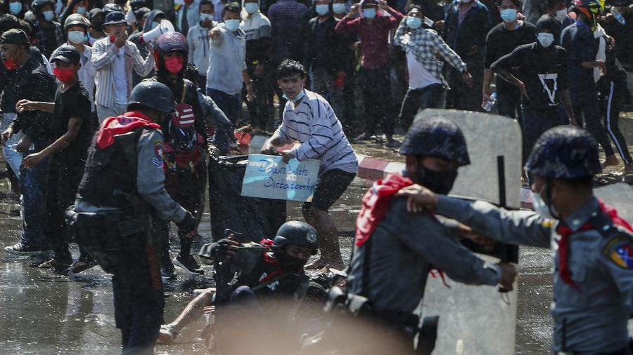 Protesters regroup after police fired warning-shots and used a water cannon to disperse them during a protest in Mandalay, Myanmar on Tuesday, Feb. 9, 2021. Police cracked down Tuesday on the demonstrators protesting against Myanmar’s military takeover who took to the streets in defiance of new protest bans. (AP Photo)