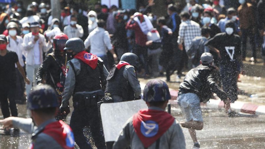 Protesters regroup after police fired warning-shots and used a water cannon to disperse them during a protest in Mandalay, Myanmar on Tuesday, Feb. 9, 2021. Police cracked down Tuesday on the demonstrators protesting against Myanmar’s military takeover who took to the streets in defiance of new protest bans. (AP Photo)